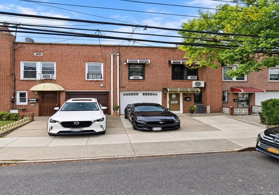 Brick facade with multiple windows, individual awnings, and integrated garage doors Brick facade with multiple windows, individual awnings, and integrated garage doors