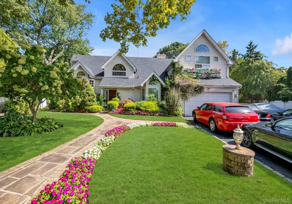View of front of home with roof with shingles, an attached garage, a front yard, a chimney, and driveway View of front of home with roof with shingles, an attached garage, a front yard, a chimney, and driveway