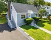 Gray siding exterior with white trim, a gabled roof, and a prominent brick chimney Gray siding exterior with white trim, a gabled roof, and a prominent brick chimney