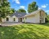 Beige siding exterior with new charcoal roof, stone accents, new windows, and a paved brick patio Beige siding exterior with new charcoal roof, stone accents, new windows, and a paved brick patio