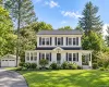 Two-story Colonial-style residence with white siding and dark shutters, featuring a covered front entry and a side porch Two-story Colonial-style residence with white siding and dark shutters, featuring a covered front entry and a side porch