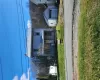 View of front of home with an outdoor structure, a metal roof, a garage, a porch, and a front lawn View of front of home with an outdoor structure, a metal roof, a garage, a porch, and a front lawn