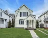 Two-story residence featuring light-colored siding and a covered front porch Two-story residence featuring light-colored siding and a covered front porch