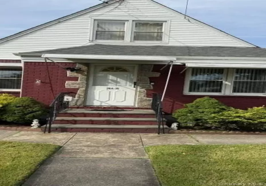 View of front of home with a shingled roof, brick siding, and a front yard View of front of home with a shingled roof, brick siding, and a front yard