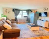 Hardwood flooring, window with natural light, wall-mounted television, and a decorative radiator cover Hardwood flooring, window with natural light, wall-mounted television, and a decorative radiator cover