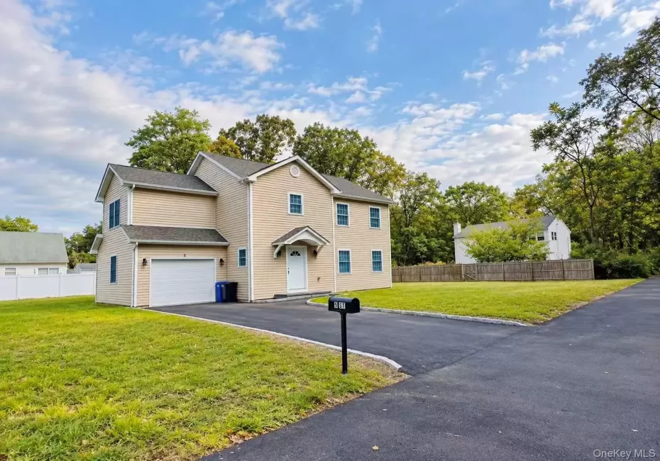 Siding exterior with a covered entry, attached garage, and paved driveway Siding exterior with a covered entry, attached garage, and paved driveway