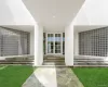 Oversized columns and elegant glass double doors frame a spectacular modern entry framed by curved glass-block privacy walls. Oversized columns and elegant glass double doors frame a spectacular modern entry framed by curved glass-block privacy walls.