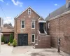 Brick exterior with a peaked roof, multiple windows, and a dark entry door Brick exterior with a peaked roof, multiple windows, and a dark entry door