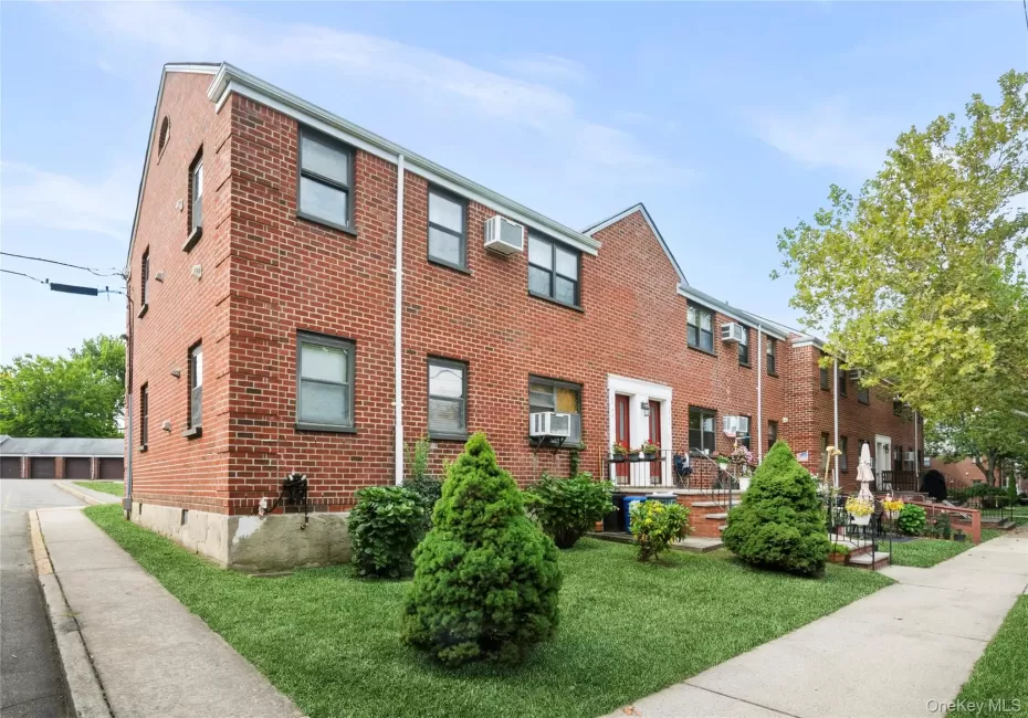 Brick exterior with multiple windows, front yard with green lawn, concrete sidewalk, and established landscaping Brick exterior with multiple windows, front yard with green lawn, concrete sidewalk, and established landscaping
