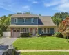 Curb view of home with one car garage, oversized driveway, brick and shingle with covered porch. Curb view of home with one car garage, oversized driveway, brick and shingle with covered porch.