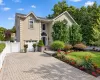 Stucco exterior with an arched entryway, integrated garage, and a paver driveway Stucco exterior with an arched entryway, integrated garage, and a paver driveway