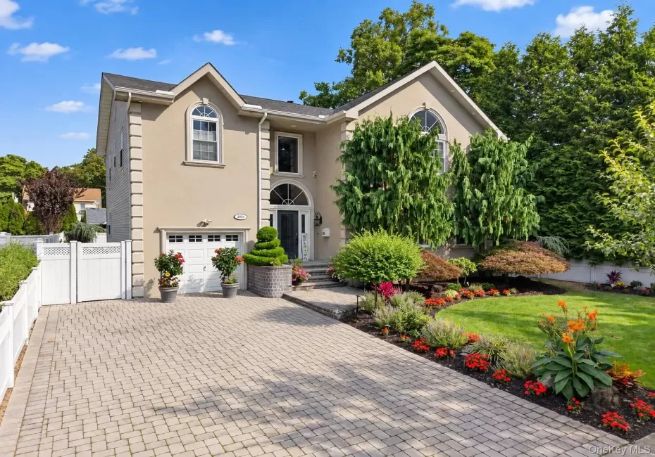 Stucco exterior with an arched entryway, integrated garage, and a paver driveway Stucco exterior with an arched entryway, integrated garage, and a paver driveway