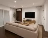 Recessed lighting, wood-finish flooring, sliding glass door, white walls, and a wall-mounted climate control unit Recessed lighting, wood-finish flooring, sliding glass door, white walls, and a wall-mounted climate control unit