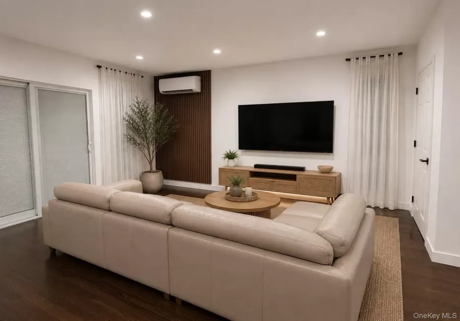 Recessed lighting, wood-finish flooring, sliding glass door, white walls, and a wall-mounted climate control unit Recessed lighting, wood-finish flooring, sliding glass door, white walls, and a wall-mounted climate control unit