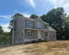 Two-story residence featuring gray siding, a covered porch, and white-framed windows Two-story residence featuring gray siding, a covered porch, and white-framed windows