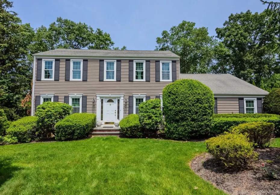Traditional exterior with beige siding, dark shutters, a white front door, and a well-maintained lawn Traditional exterior with beige siding, dark shutters, a white front door, and a well-maintained lawn