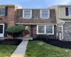 Brick facade featuring a brown shingle mansard roof and white window trim Brick facade featuring a brown shingle mansard roof and white window trim