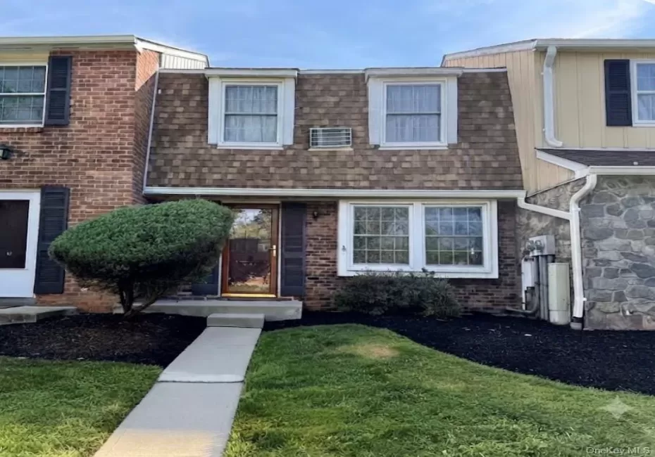 Brick facade featuring a brown shingle mansard roof and white window trim Brick facade featuring a brown shingle mansard roof and white window trim