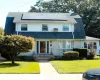 Gambrel roofline with solar panels, white siding, brick chimney, covered entry, and bay window Gambrel roofline with solar panels, white siding, brick chimney, covered entry, and bay window
