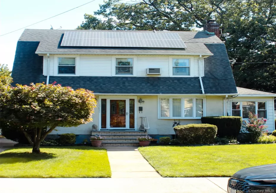 Gambrel roofline with solar panels, white siding, brick chimney, covered entry, and bay window Gambrel roofline with solar panels, white siding, brick chimney, covered entry, and bay window