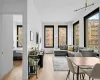 Living room with light wood-style floors, plenty of natural light, and a baseboard heating unit Living room with light wood-style floors, plenty of natural light, and a baseboard heating unit