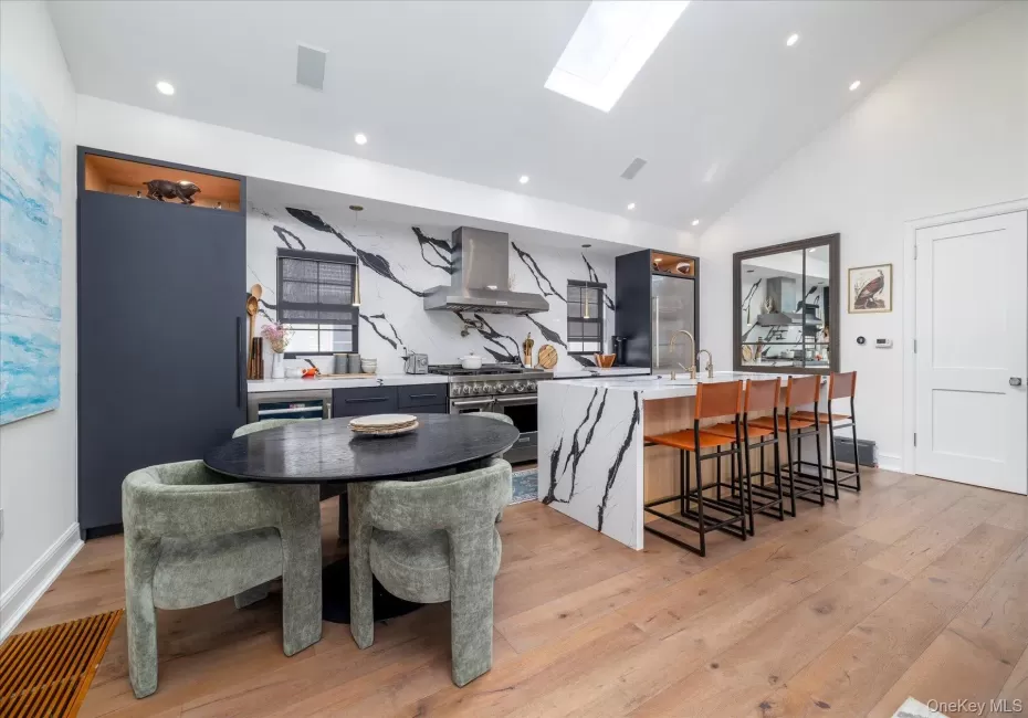 Large kitchen with stainless steel appliances, a large island with seating for 4 and a separate dining table Large kitchen with stainless steel appliances, a large island with seating for 4 and a separate dining table