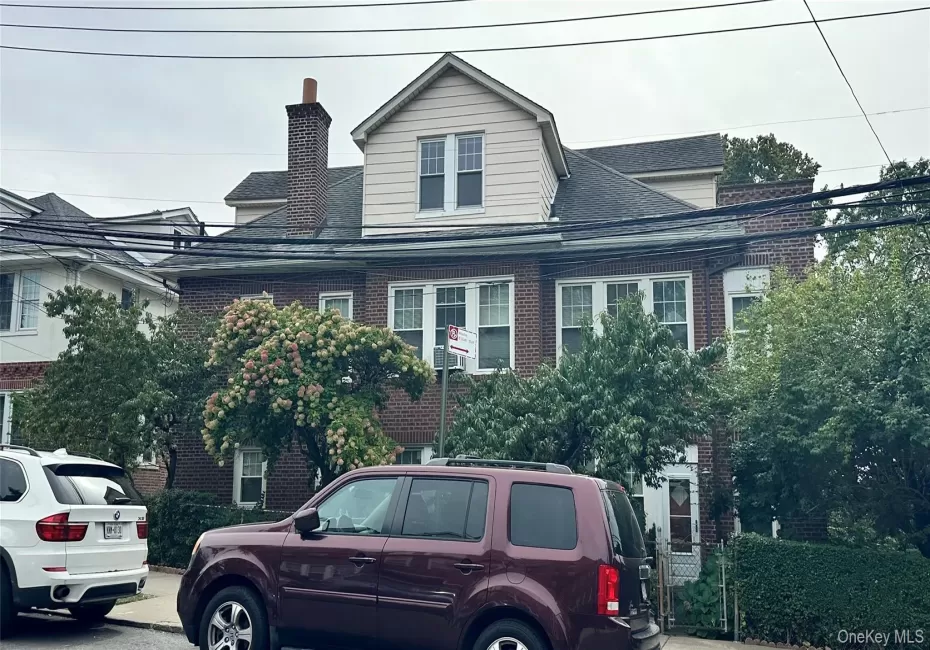 Brick exterior featuring a gabled dormer and a prominent brick chimney Brick exterior featuring a gabled dormer and a prominent brick chimney