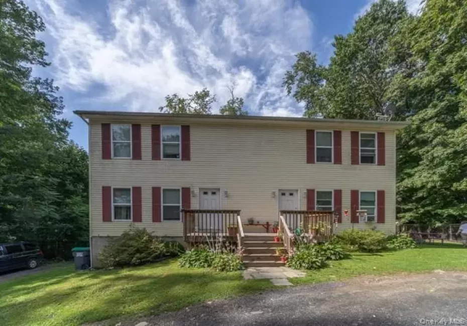 Two-story duplex with light-colored siding and red shutters Two-story duplex with light-colored siding and red shutters