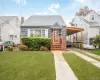 View of front of home featuring a front yard, a shingled roof, and brick siding View of front of home featuring a front yard, a shingled roof, and brick siding