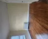 Hardwood flooring, painted walls, baseboard trim, window with blinds, and a radiator Hardwood flooring, painted walls, baseboard trim, window with blinds, and a radiator