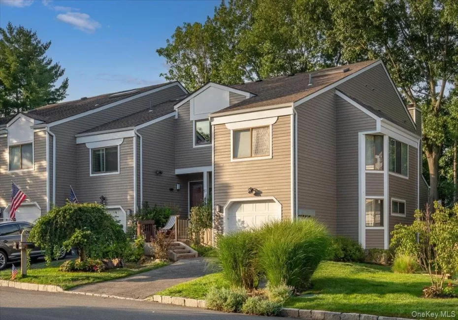 Siding exterior featuring a pitched roofline, attached garage, and established landscaping Siding exterior featuring a pitched roofline, attached garage, and established landscaping