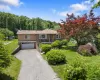 Ranch-style house featuring a garage, asphalt driveway, and a front yard Ranch-style house featuring a garage, asphalt driveway, and a front yard