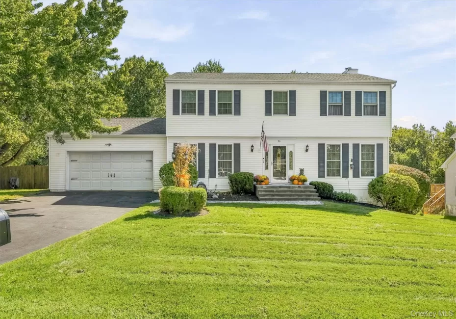 White siding exterior with dark shutters, attached two-car garage, and established front landscaping White siding exterior with dark shutters, attached two-car garage, and established front landscaping