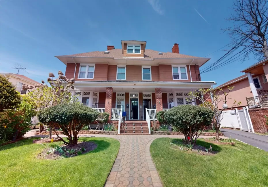 Traditional style home with a chimney, a porch, and a front lawn Traditional style home with a chimney, a porch, and a front lawn