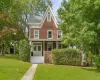 Gabled roofline, front porch, double entry doors, front lawn, and mature trees Gabled roofline, front porch, double entry doors, front lawn, and mature trees