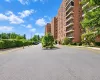 Brick-clad building with multiple private balconies, a circular driveway, and mature perimeter landscaping Brick-clad building with multiple private balconies, a circular driveway, and mature perimeter landscaping