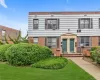 Brick and shingle exterior with decorative shutters, mature landscaping, and a manicured lawn Brick and shingle exterior with decorative shutters, mature landscaping, and a manicured lawn