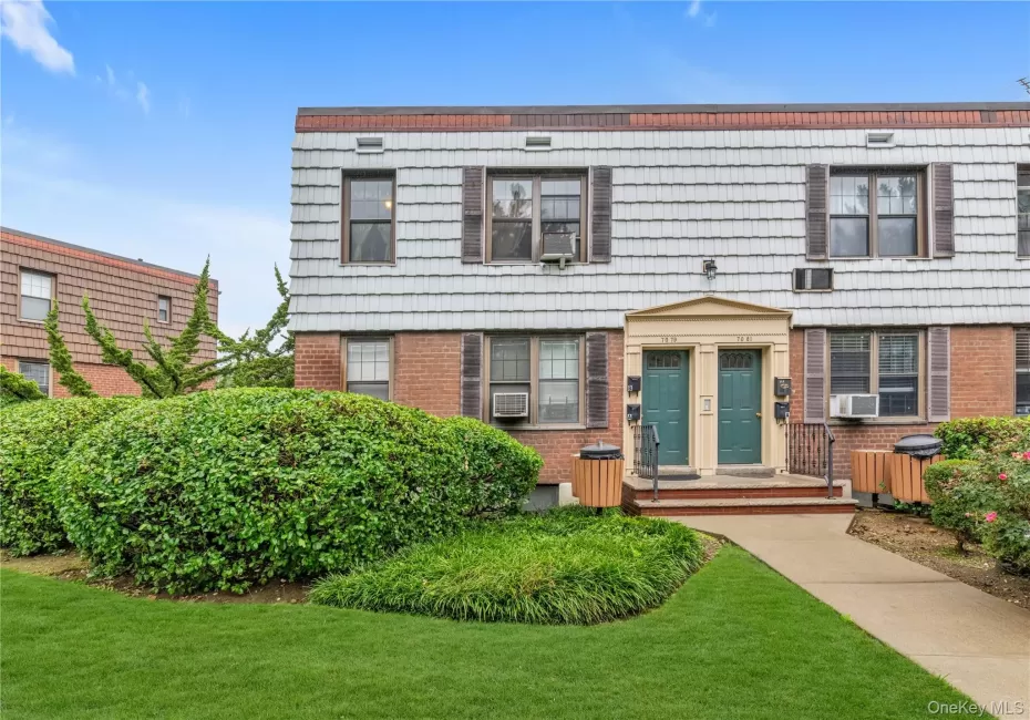 Brick and shingle exterior with decorative shutters, mature landscaping, and a manicured lawn Brick and shingle exterior with decorative shutters, mature landscaping, and a manicured lawn