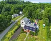 Expansive property featuring a brick and siding exterior, solar panel installation, attached two-car garage, and a substantial green lawn Expansive property featuring a brick and siding exterior, solar panel installation, attached two-car garage, and a substantial green lawn