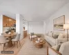 Open-concept living space featuring vinyl flooring, recessed lighting, and a kitchen with wood cabinetry and stainless steel appliances Open-concept living space featuring vinyl flooring, recessed lighting, and a kitchen with wood cabinetry and stainless steel appliances