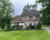 View of front of property featuring a gazebo, a front lawn, and a shingled roof View of front of property featuring a gazebo, a front lawn, and a shingled roof
