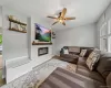 Living space with a shiplap feature wall, integrated electric fireplace, wood-finish mantel, and ceiling fan Living space with a shiplap feature wall, integrated electric fireplace, wood-finish mantel, and ceiling fan