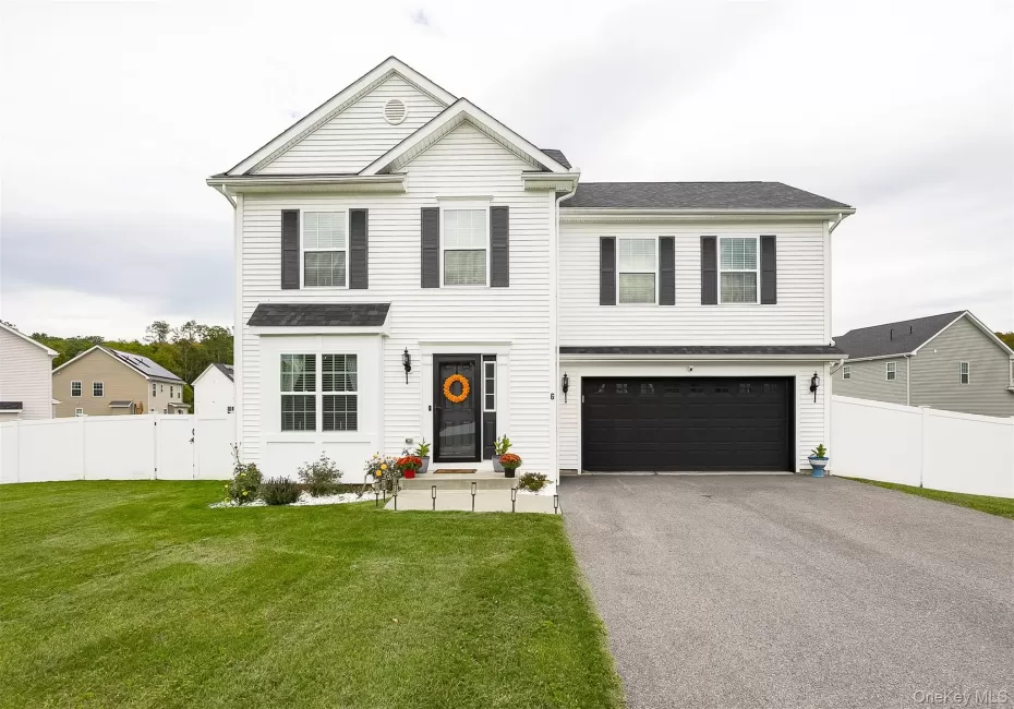 Two-story residence featuring white siding, black shutters, a two-car garage, and a fenced backyard Two-story residence featuring white siding, black shutters, a two-car garage, and a fenced backyard
