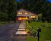 Split-level residence featuring a paved driveway, stone retaining walls, and a multi-level stone walkway. Split-level residence featuring a paved driveway, stone retaining walls, and a multi-level stone walkway.