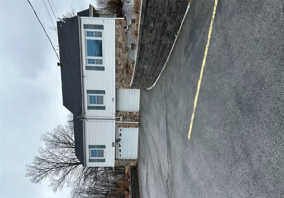 View of front facade with aphalt driveway, roof with shingles, and an attached garage View of front facade with aphalt driveway, roof with shingles, and an attached garage