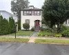 Two-story residence with dormer, prominent red entry door, and stone steps Two-story residence with dormer, prominent red entry door, and stone steps