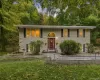 Bi-level residence featuring light-toned siding, a vibrant red entry door with an arched transom, and black window shutters Bi-level residence featuring light-toned siding, a vibrant red entry door with an arched transom, and black window shutters