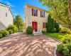 Two-story residence with light-colored siding and a red front door Two-story residence with light-colored siding and a red front door