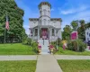 Victorian-style exterior with a prominent turret, wraparound porch, and vibrant landscaping Victorian-style exterior with a prominent turret, wraparound porch, and vibrant landscaping