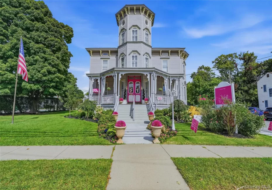 Victorian-style exterior with a prominent turret, wraparound porch, and vibrant landscaping Victorian-style exterior with a prominent turret, wraparound porch, and vibrant landscaping